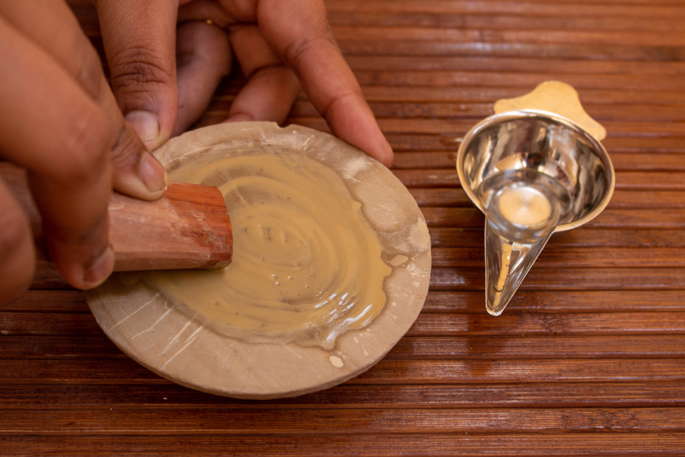 Extraction of sandalwood paste from the sandalwood using a stone and adding water