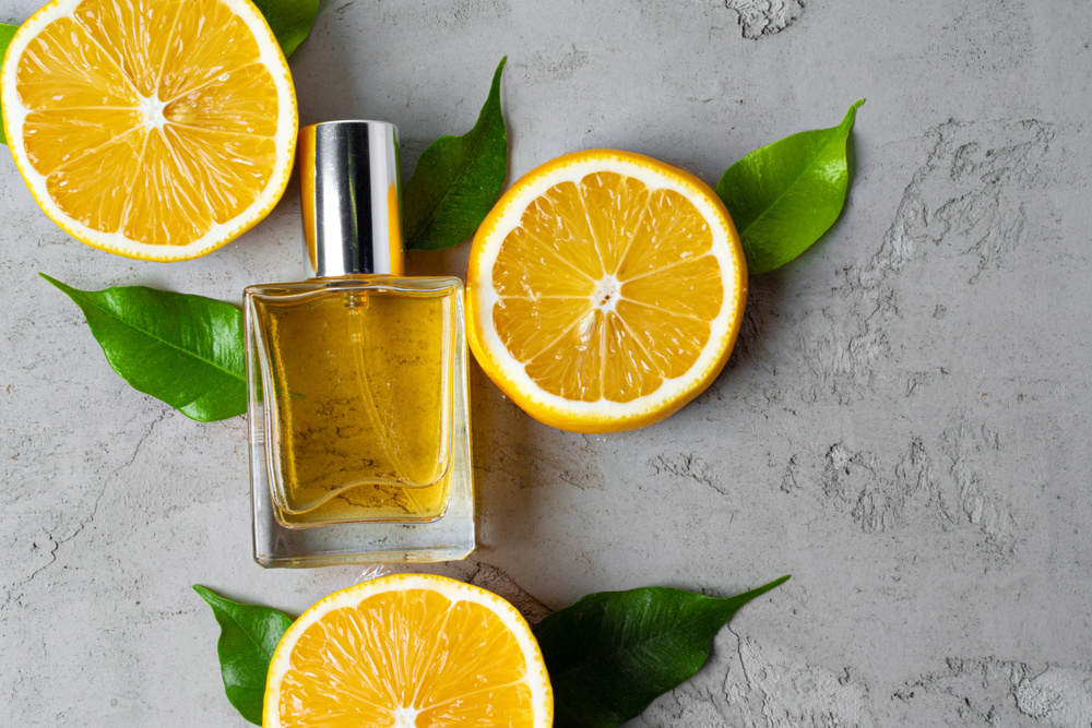 A bottle of perfume and citrus fruits