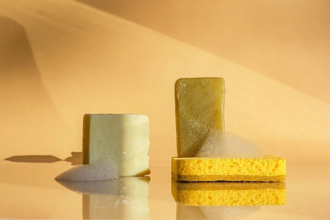 soap bars and a sponge with a yellow background