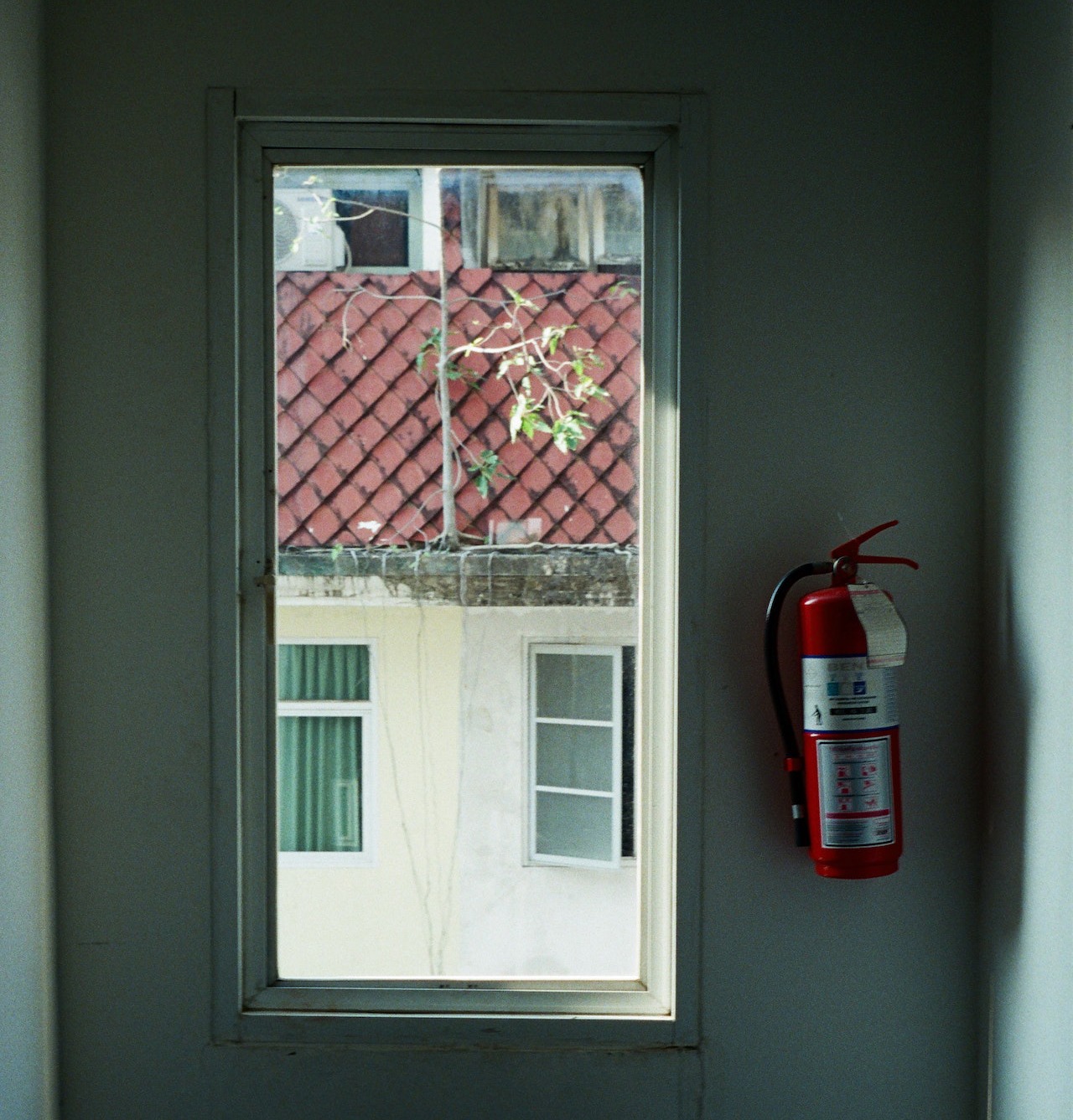a fire extinguisher hanging near a window