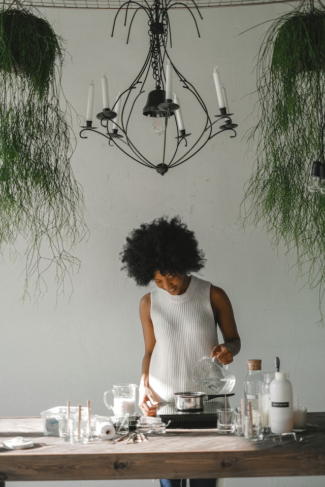 ethnic craftswoman making candles in modern workshop