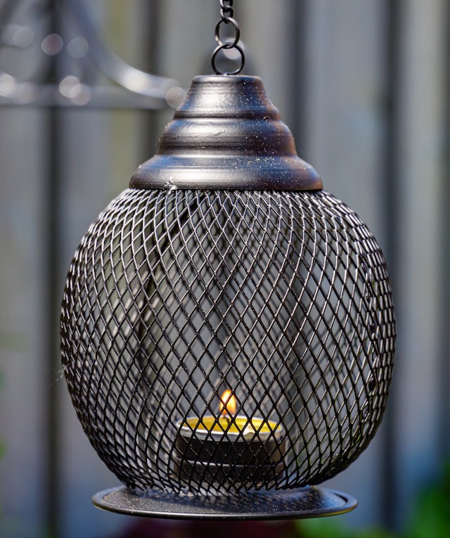 lit up tealight candle in iron cage