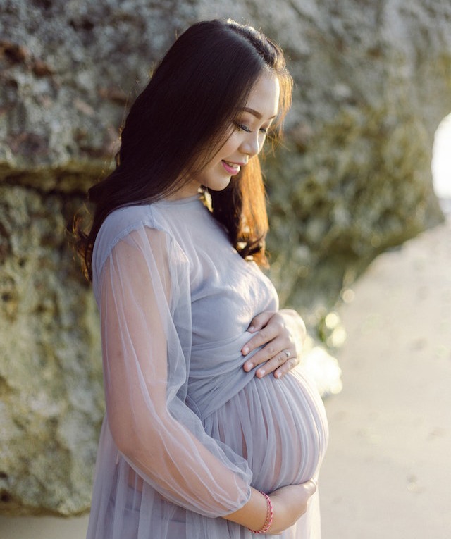 photo of pregnant woman wearing purple dress
