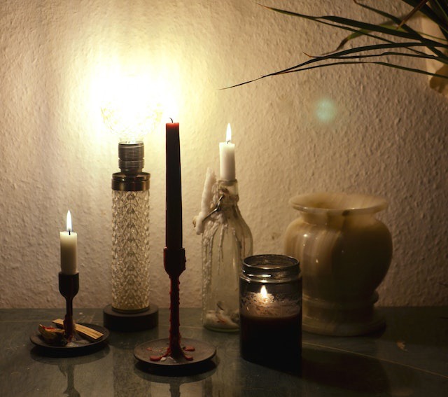 table with candles and lamp in dark room